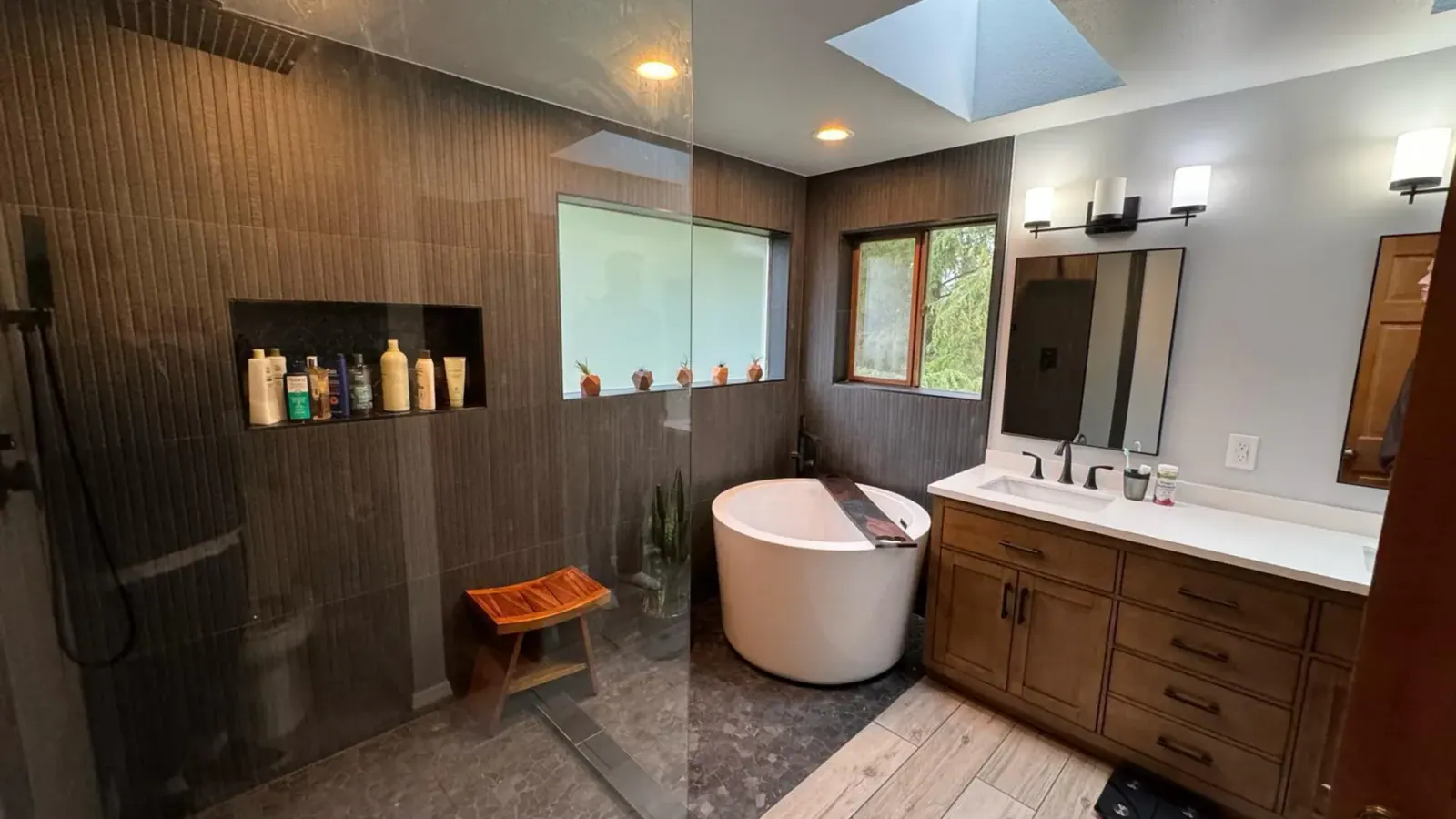 Finished Renton basement bathroom with glass shower, freestanding tub, and wood vanity Finished Renton basement bathroom with glass shower, freestanding tub, and wood vanity